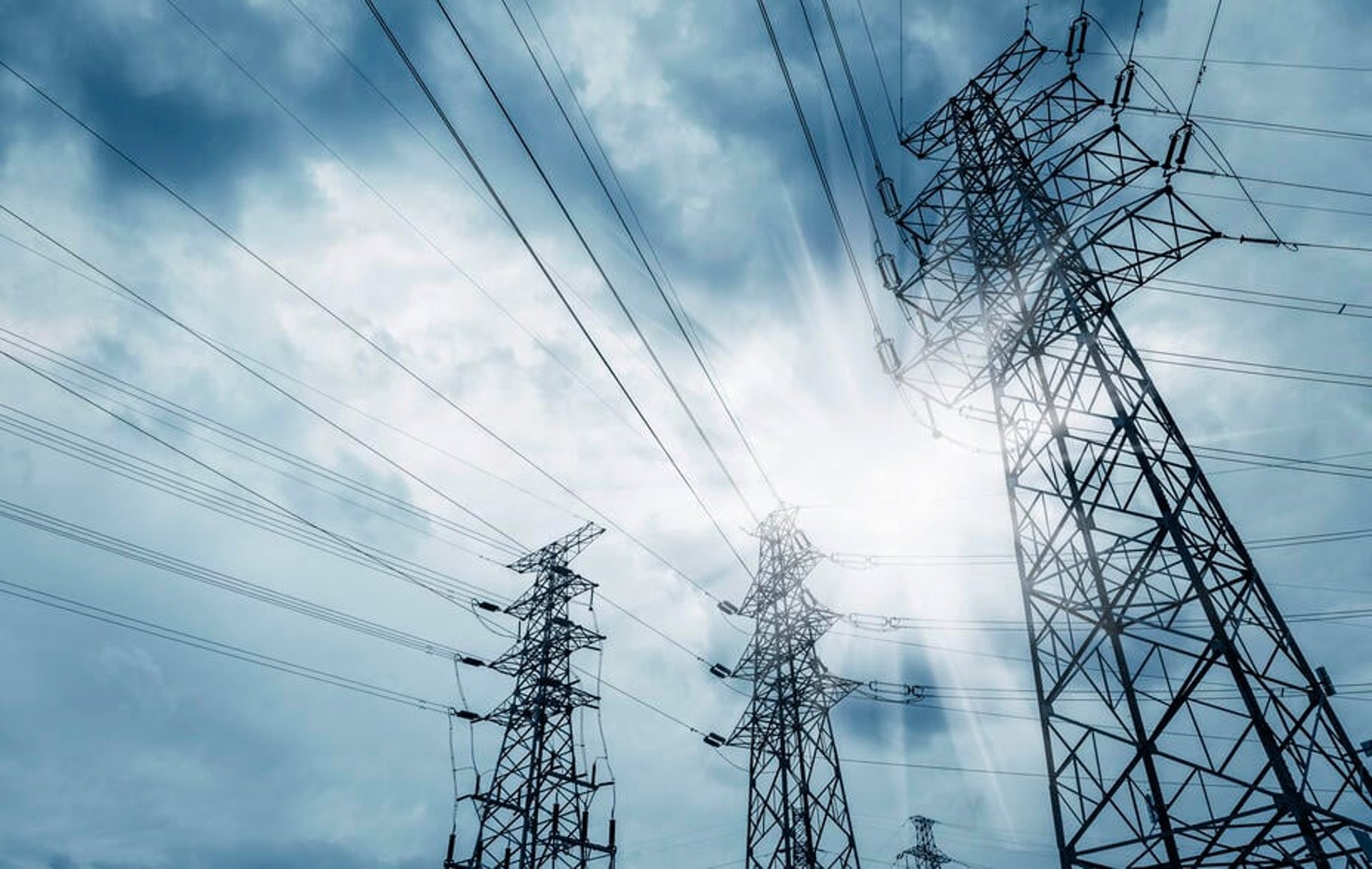 Pylons looming in silhouette against a grey-blue sky.