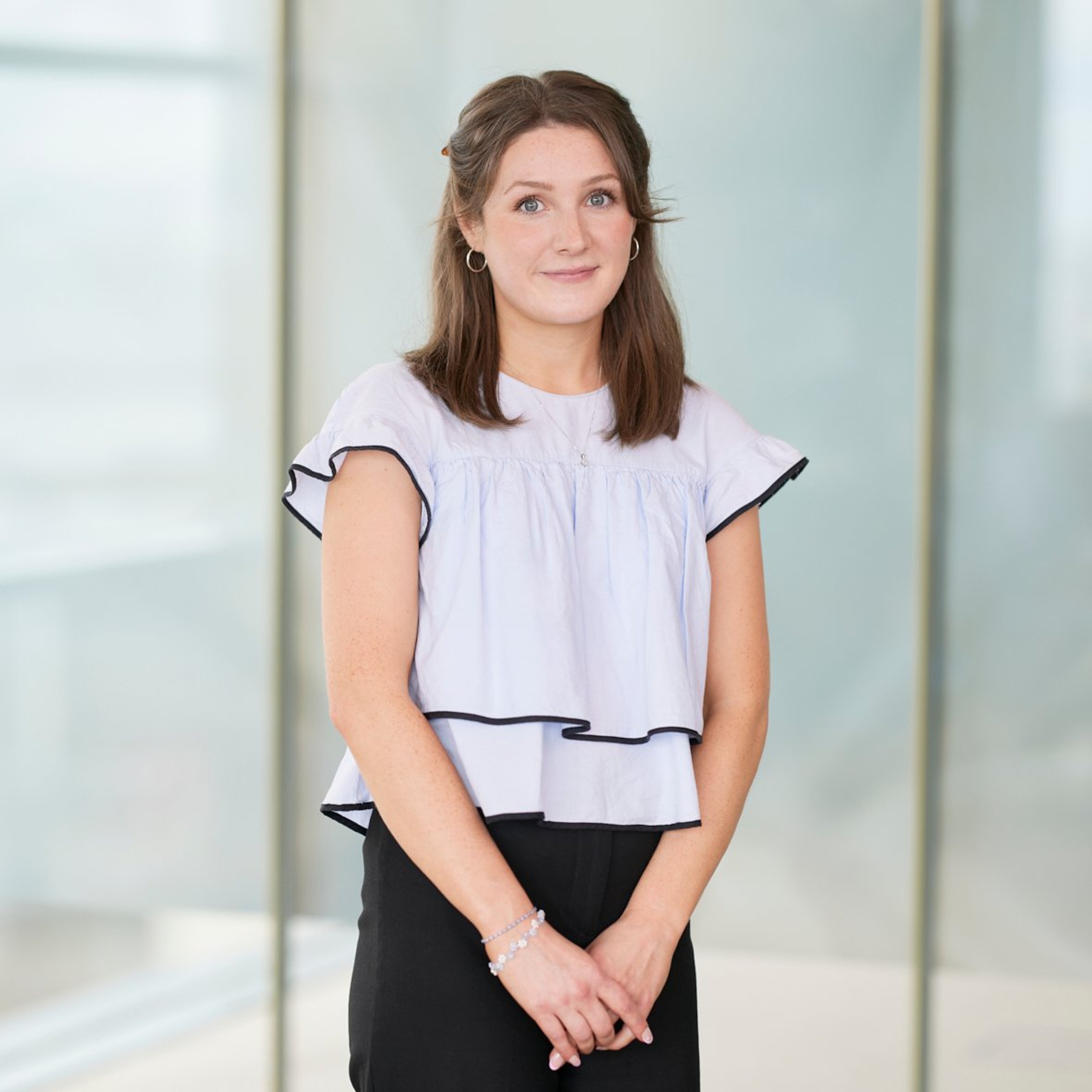 Lucy Lewin standing with her arms at her front.