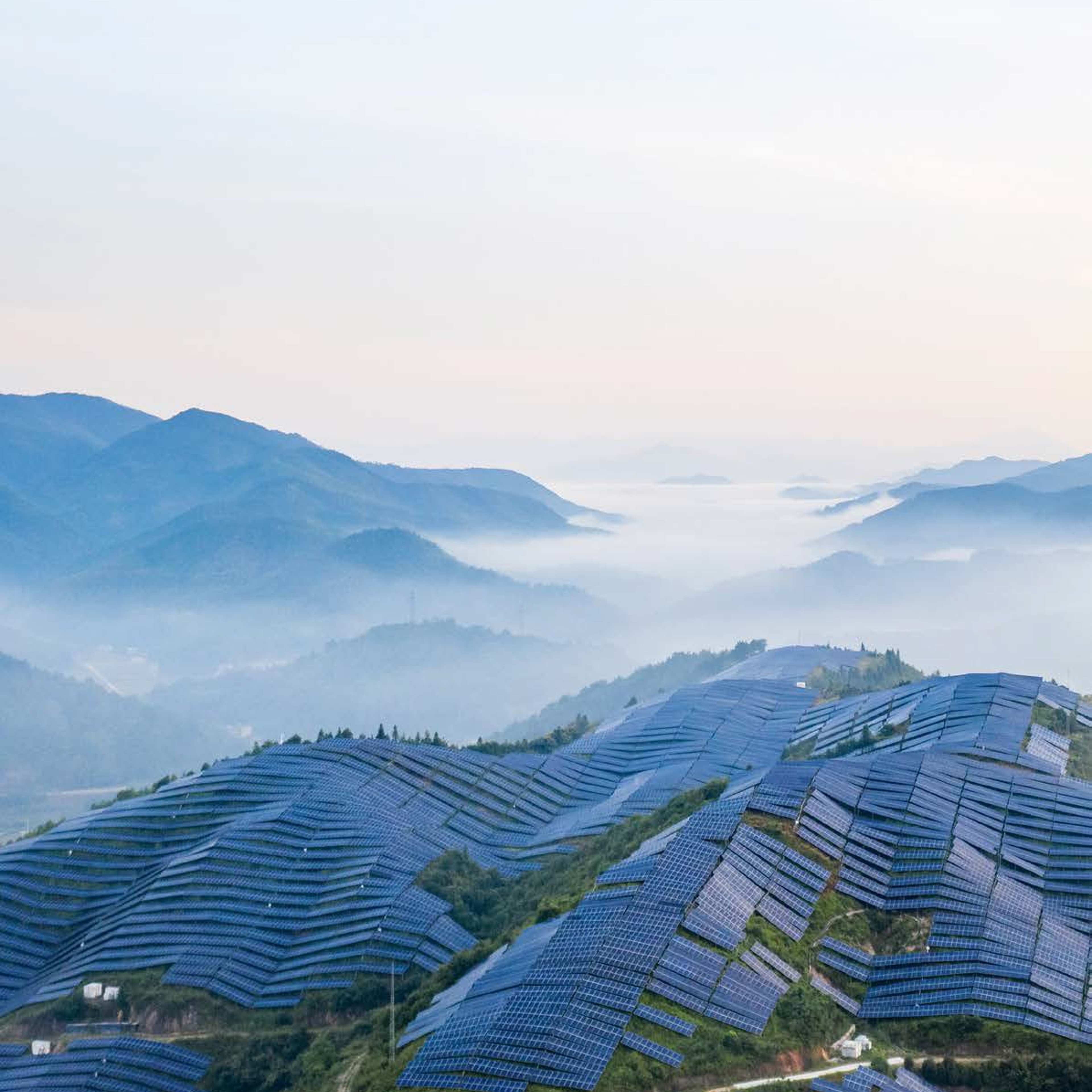 solar panels on a hill with a mountain backdrop